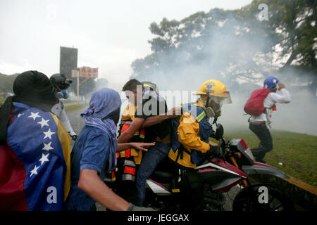 Naguanagua, Carabobo, Venezuela. Il 24 giugno 2017. Il giovane Juan Flores è stato influenzato dal gas dolori durante la protesta è coadiuvato da membri del personale paramedico, nel marzo del messaggio a ff a nn che è stata una visita al fort Paramacay, in Naguanagua, Carabobo stato. Foto: Juan Carlos Hernandez Credito: Juan Carlos Hernandez/ZUMA filo/Alamy Live News Foto Stock