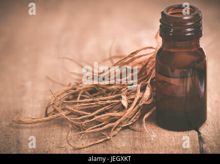 Estratto di cannabis con foglie secche su una superficie di legno Foto Stock