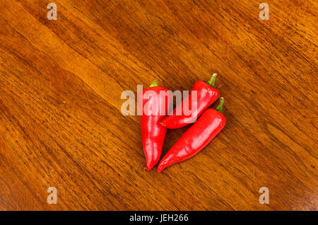 Tre rossi peperoncini jalapeno sulla tavola di legno Foto Stock