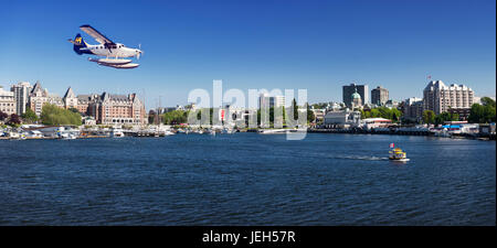 Porto aria idrovolante atterraggio su acqua e H2O taxi del mare barca taxi di fronte a un panorama di Victoria BC Harbour Front skyline. Victoria, Vanco Foto Stock