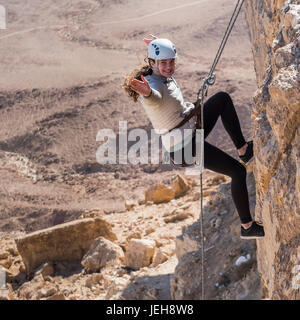 Una giovane donna rappelling nel cratere Ramon, Ramon Riserva; Mitzpe Ramon, Distretto Sud, Israele Foto Stock