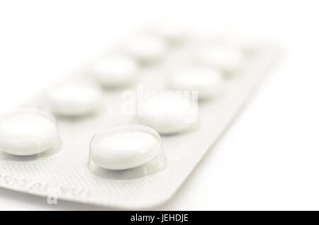 Le compresse di contraccettivi in pacchetti e senza su uno sfondo luminoso. Foto Stock