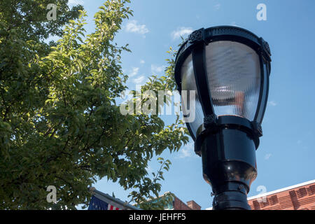 Direttamente sotto il colpo di luce di strada contro Sky alberi e costruire bordatura del tetto Foto Stock