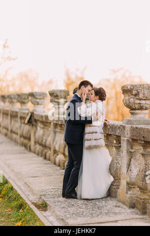 La foto sensibile degli sposi appoggiata sul vecchio recinto. La sposa è come accarezzare il volto del suo sposo. Foto Stock