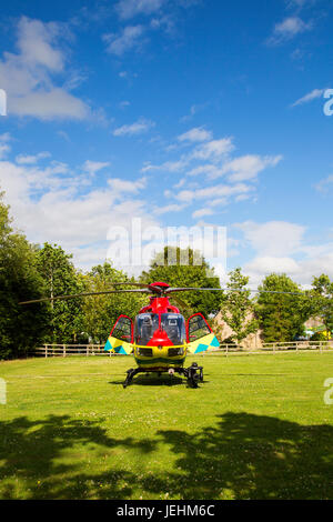 La Thames Valley Air Ambulance terre in un campo di Oxfordshire prima di trasportare un malato gravemente ferito in ospedale. Foto Stock