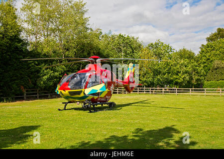 La Thames Valley Air Ambulance terre in un campo di Oxfordshire prima di trasportare un malato gravemente ferito in ospedale. Foto Stock