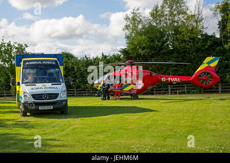 La Thames Valley Air Ambulance terre in un campo di Oxfordshire prima di trasportare un malato gravemente ferito in ospedale. Foto Stock