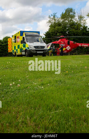 La Thames Valley Air Ambulance terre in un campo di Oxfordshire prima di trasportare un malato gravemente ferito in ospedale. Foto Stock