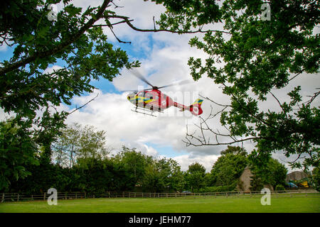 La Thames Valley Air Ambulance terre in un campo di Oxfordshire prima di trasportare un malato gravemente ferito in ospedale. Foto Stock