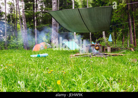 La mattina presto nel campo in tenda al bordo della foresta Foto Stock