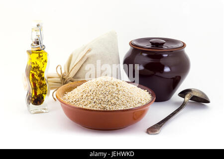 La composizione dell'orzo Semole in argilla pial accanto a una pentola di creta e un cucchiaio di rame, Foto Stock