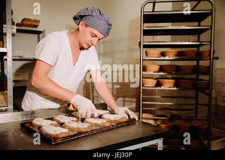 Baker lavorazione dell'impasto e la formazione di pagnotta di pane Foto Stock
