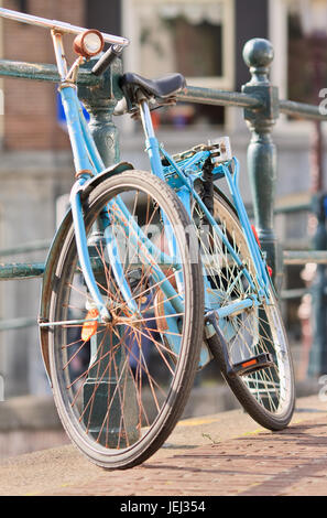 AMSTERDAM-20 LUGLIO 2009. Bicicletta blu d'epoca parcheggiata contro una ringhiera. Con 881,000 la città ha più biciclette che residenti. Foto Stock