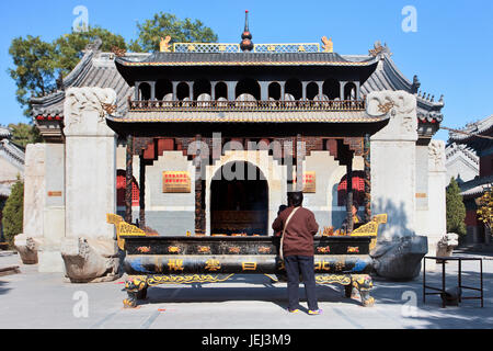 PECHINO – OTT. 30, 2010. Donna brucia incenso su un altare al tempio di Bai Yun Guan. Significa Tempio della nuvola Bianca (Daoista) fondato a metà dell'VIII secolo. Foto Stock