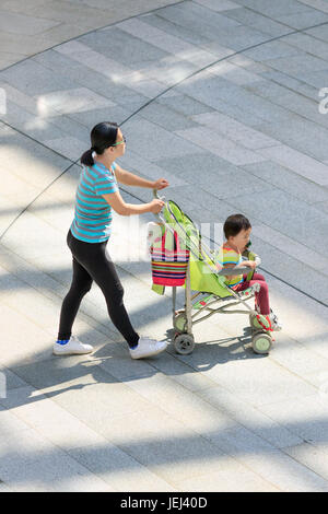 PECHINO-18 MAGGIO 2016. Donna con baby car nel centro commerciale. La Cina è molto preoccupata per l’invecchiamento della popolazione e ha posto fine alla sua politica di un figlio unico. Foto Stock