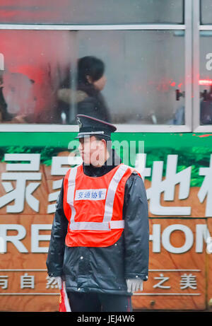 HEFEI-CINA-JAN. 6, 2009. Poliziotto angosciato una mattina presto piovosa. A differenza della polizia statunitense o di Hong Kong, la maggior parte dei poliziotti in Cina non hanno armi da fuoco. Foto Stock