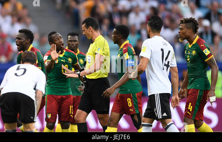 Sotschi, Russland. Il 25 giugno, 2017. Fußball: Confederations Cup, Deutschland - Kamerun, Vorrunde, Gruppe B, 3. Spieltag am 25.06.2017 in Fisht Stadium, Sotschi. Emre può (2.vr) aus Deutschland schaut zu während Schiedsrichter Wilmar Roldán aus Kolumbien nach einem fallo mit Bassogog cristiana aus Kamerun diskutiert. Nach Videobeweis sieht schließlich Ernest Mabouka (4.vl., 2) aus Kamerun die rote Karte und muss vom Platz gehen. Foto: Marius Becker/dpa/Alamy Live News Foto Stock