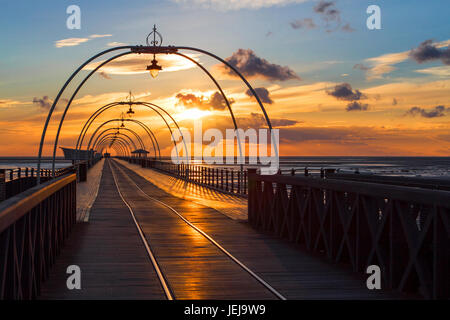Southport, Merseyside, 25 giugno 2017. Regno Unito Meteo. Un tramonto mozzafiato si appoggia sul molo a Southport nel Merseyside. Aperto per la prima volta nel 1860, si estende per una lunghezza di 1.108 metri (3,635 piedi) ed è il secondo più lungo in Gran Bretagna. Esso è stato elencato in grado II il 18 agosto 1975. La tramvia eseguito dalla passeggiata al Pier Head a varie volte nel molo di storia, e più recentemente da agosto 2005 fino a giugno 2015. Credito: Cernan Elias/Alamy Live News Foto Stock