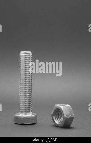 Avvitare le viti e i dadi su sfondo nero Foto Stock