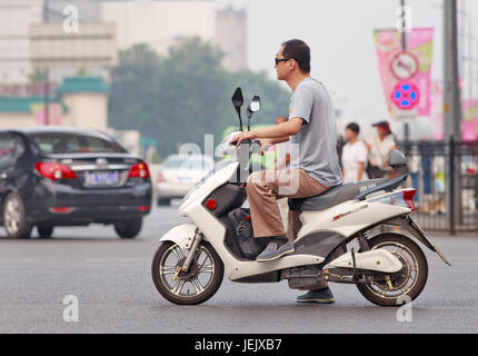 PECHINO-27 LUGLIO 2015. Uomo su nuova e-bike. In un decennio, le e-bike in Cina sono salite da quasi zero a oltre 150 milioni entro il 2015. Foto Stock