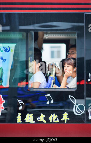 CHANGCHUN-CINA-LUGLIO 8. Ragazza sognante che ascolta musica sull'autobus. La modalità di trasporto più popolare tra i pendolari cinesi è l'autobus. Foto Stock