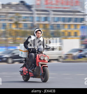 Di YIWU-cina-gen. 26, 2016. Un uomo su un gas scooter. Il Governo vuole vietare uscire i gas scooter e motociclette che sono popolari in città cinesi. Foto Stock