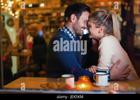 Felice coppia attraente kissing a barra avente data