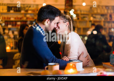Felice coppia attraente kissing a barra avente data