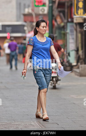 PECHINO-9 GIUGNO 2015. Donna di mezza età in via dello shopping. La vita delle donne in Cina è cambiata in modo significativo dopo che il governo ha fatto grandi sforzi. Foto Stock