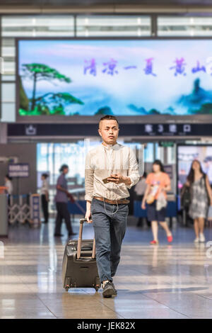 PECHINO-21 MAGGIO 2016. Giovane uomo alla stazione ferroviaria di Pechino Sud, la stazione più grande della città, una delle più grandi in Asia, capolinea treni ad alta velocità. Foto Stock