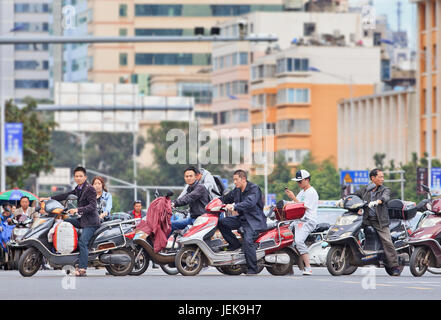 KUNMING-30 GIUGNO 2014. Uomini in bicicletta elettronica nel centro della città. Molte bici elettriche in Cina sono lo scooter stile e-bike che può o non può avere pedali. Foto Stock