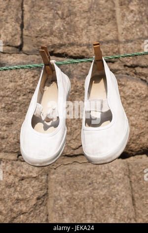 Scarpe cinesi appendere su una linea di lavanderia a secco Foto Stock
