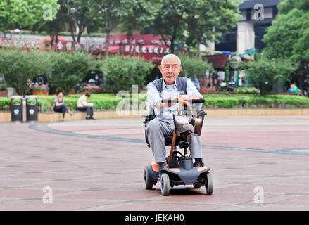 Anziani cinese in un elettrico mini auto. La popolazione di anziani (60 o più vecchio) in Cina è di circa 128 milioni di euro, il più grande del mondo. Foto Stock