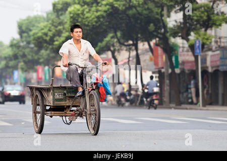 Cargo bike sulla strada. Anche se il loro numero è in declino, carico di biciclette e tricicli di nolo sono ancora una popolare modalità di trasporto in Cina. Foto Stock