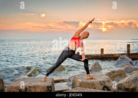 Donna che esercitano sul mare, stretching Foto Stock