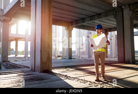 Immagine del sito in costruzione ingegnere guardando al piano di costruzione Foto Stock