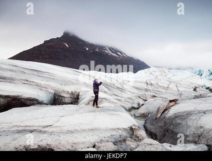 Uomo di fotografare ghiacciaio Svinafellsjokull, Islanda Foto Stock