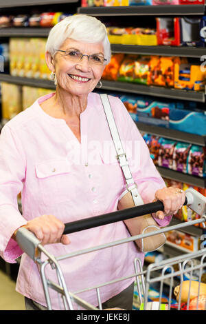 Sorridente donna senior carrello di spinta Foto Stock