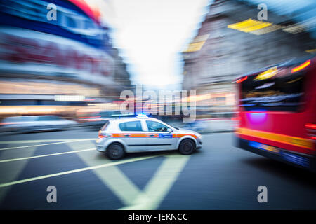 Police Car in Motion - Motion Blur - UN'auto di polizia metropolitana di Londra corre attraverso Piccadilly Circus nel centro di Londra con luci blu lampeggianti Foto Stock