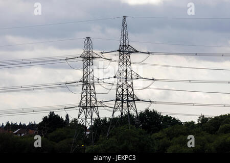 Tralicci di energia elettrica e di alimentazione dei cavi di trasmissione nella campagna del fiume inferiore Prova, Totton, vicino a Southampton, Hants, Regno Unito sotto le nuvole scure Foto Stock