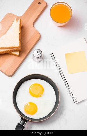 Vista superiore della tradizionale facile sana colazione veloce pasto fatto di uova fritte servite su una padella. Foto Stock