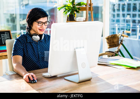 Sorridente imprenditore asiatico tramite il computer Foto Stock