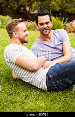 Felice coppia gay sdraiati sull'erba Foto Stock