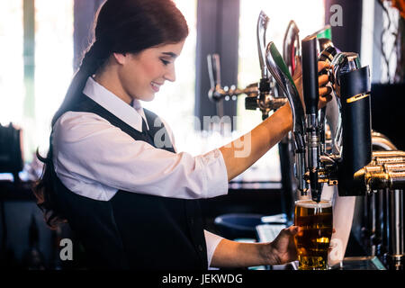 Barista serve una pinta Foto Stock