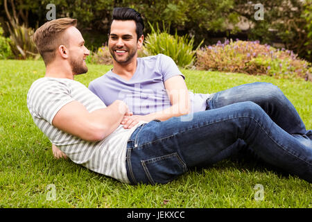 Felice coppia gay sdraiati sull'erba Foto Stock