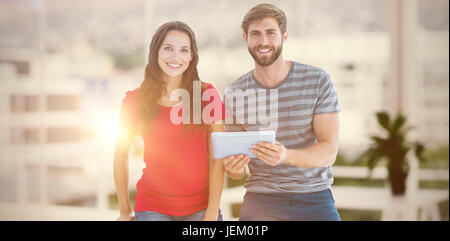 Immagine composita del giovane in posa con la compressa Foto Stock