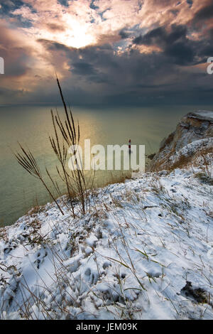 Guardando oltre Beachy Head verso il faro con il suolo coperto di neve e un altro tempesta di neve di avvicinamento . Foto Stock