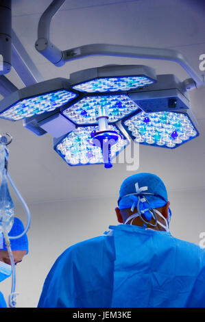 Surgical team di lavoro mediante cool illuminazione direzionale Foto Stock