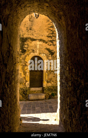 Strada laterale e porta di Saint-Guilhem-le-Désert etichettati Les Plus Beaux Villages de France. Herault. Francia Foto Stock