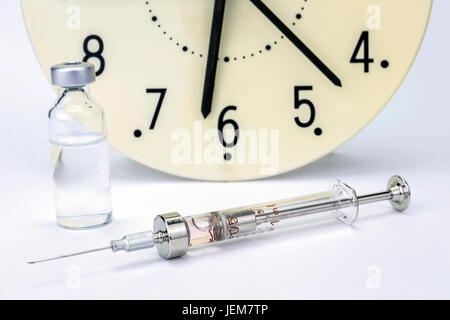 Medicina e fiale siringa, l'orologio mostra il tempo del farmaco Foto Stock